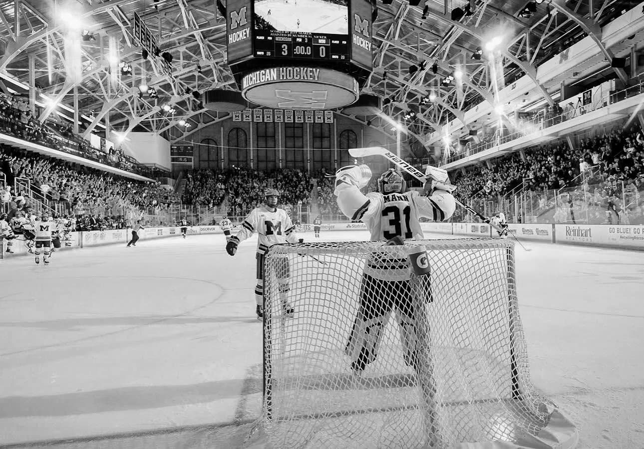 A goalie in the crease before a packed arena