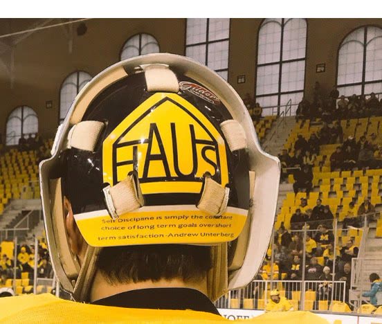 A goalie mask painted with HAUS